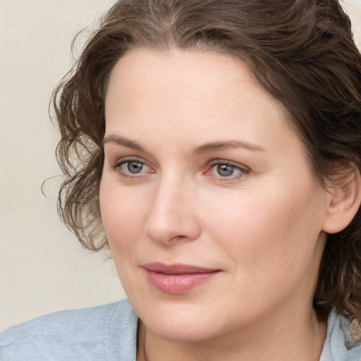 Joyful white young-adult female with medium  brown hair and green eyes