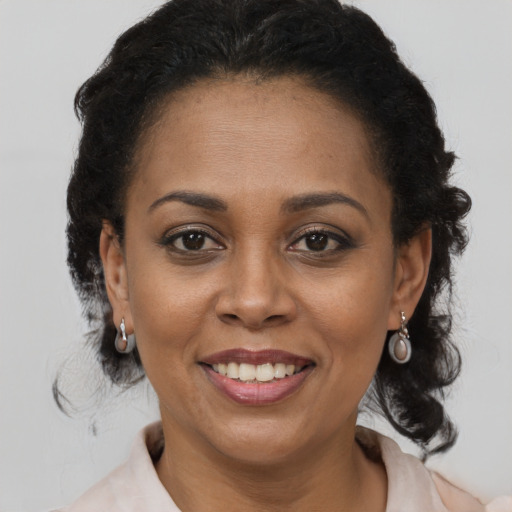 Joyful latino adult female with medium  brown hair and brown eyes