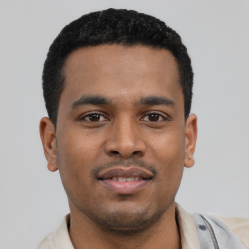 Joyful latino young-adult male with short  black hair and brown eyes