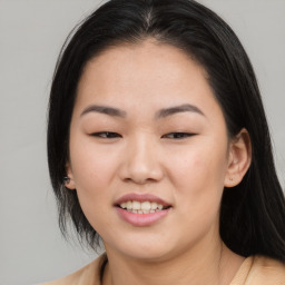 Joyful asian young-adult female with long  brown hair and brown eyes