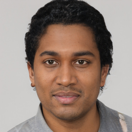 Joyful black young-adult male with short  black hair and brown eyes