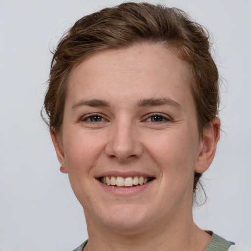 Joyful white young-adult female with short  brown hair and grey eyes