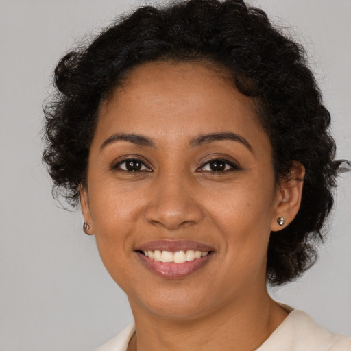 Joyful latino young-adult female with short  brown hair and brown eyes