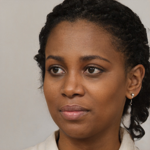 Joyful black young-adult female with medium  black hair and brown eyes