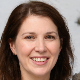 Joyful white adult female with long  brown hair and brown eyes