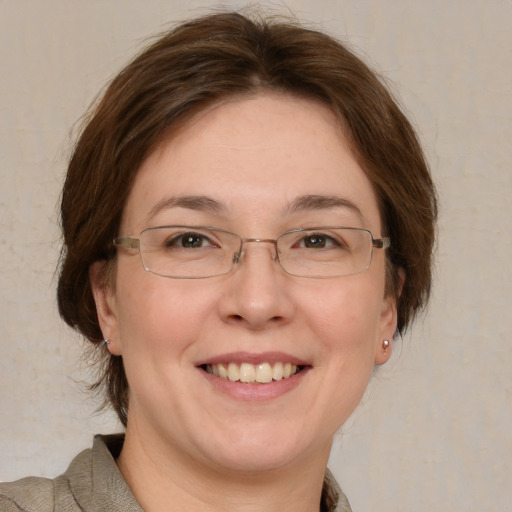 Joyful white adult female with medium  brown hair and green eyes