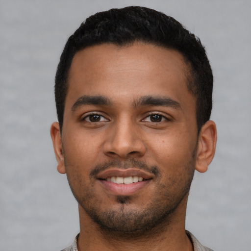 Joyful latino young-adult male with short  brown hair and brown eyes