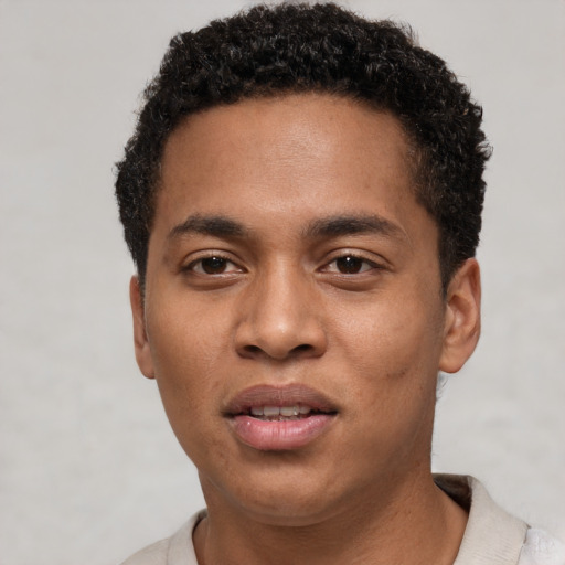 Joyful black young-adult male with short  brown hair and brown eyes