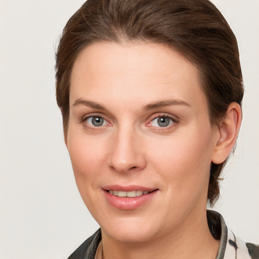 Joyful white young-adult female with medium  brown hair and grey eyes