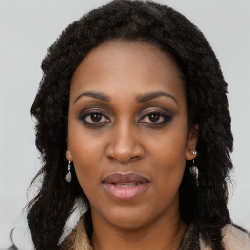 Joyful black young-adult female with long  black hair and brown eyes
