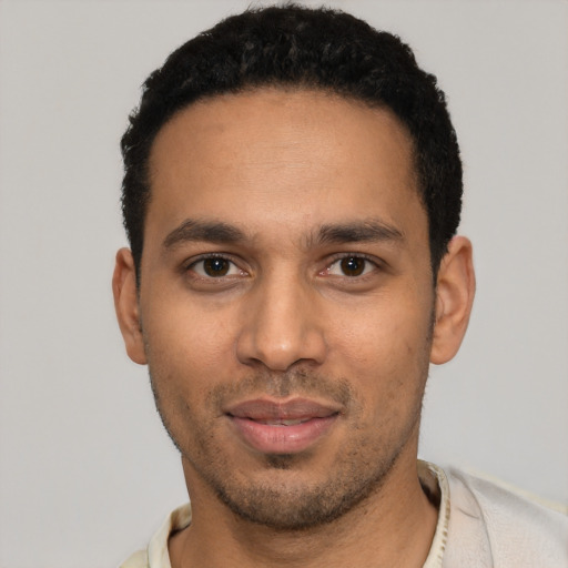 Joyful latino young-adult male with short  black hair and brown eyes