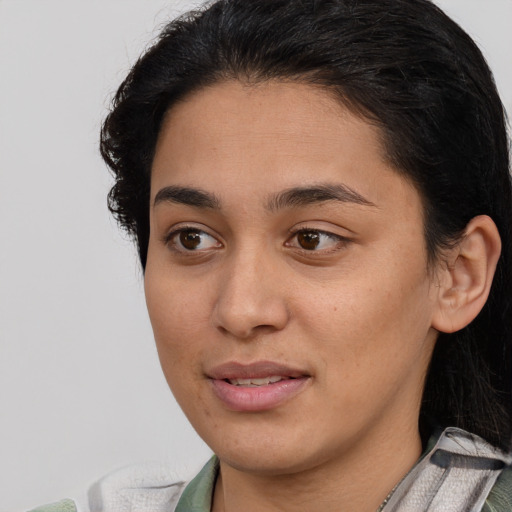 Joyful latino young-adult female with medium  brown hair and brown eyes