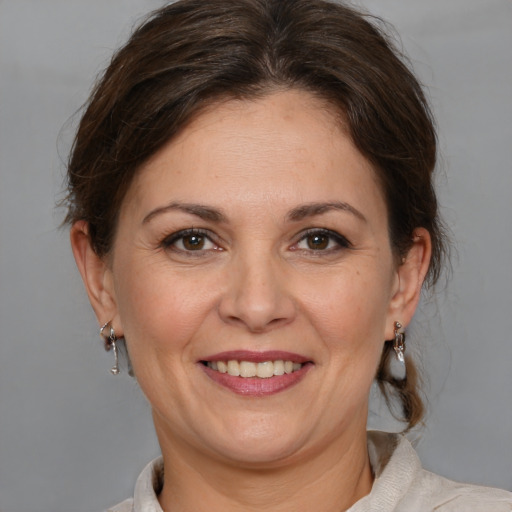 Joyful white adult female with medium  brown hair and brown eyes