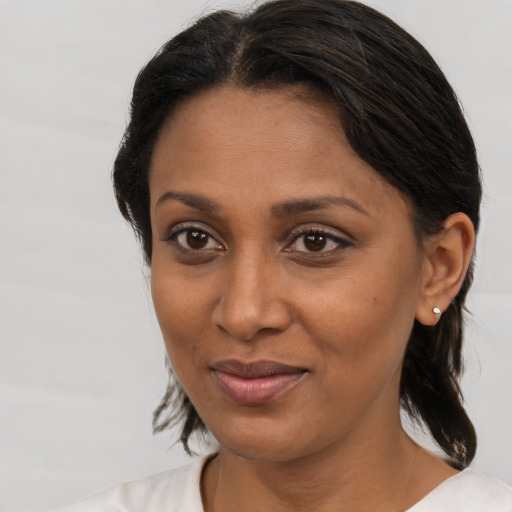 Joyful black young-adult female with medium  brown hair and brown eyes