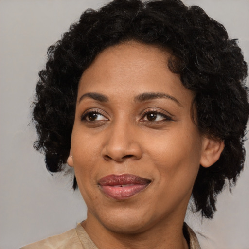Joyful black adult female with medium  brown hair and brown eyes