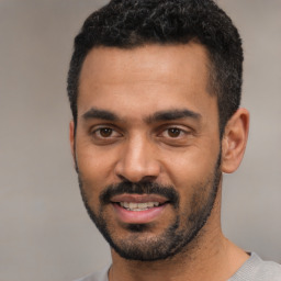 Joyful black young-adult male with short  black hair and brown eyes