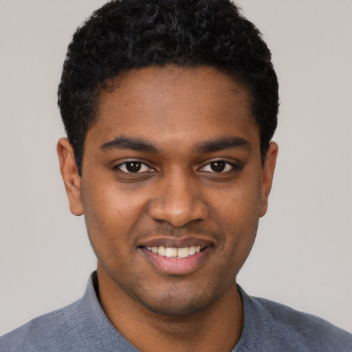 Joyful black young-adult male with short  black hair and brown eyes