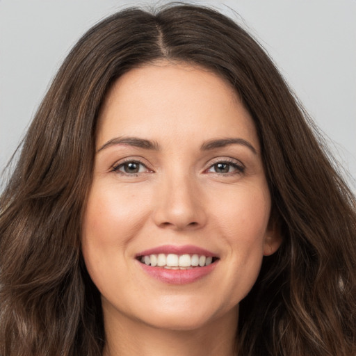 Joyful white young-adult female with long  brown hair and brown eyes