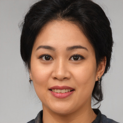 Joyful asian young-adult female with medium  brown hair and brown eyes
