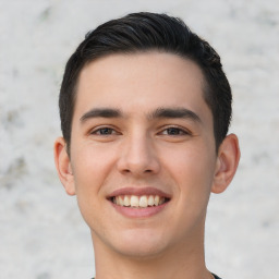 Joyful white young-adult male with short  black hair and brown eyes