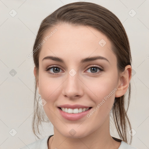 Joyful white young-adult female with medium  brown hair and grey eyes