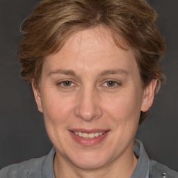 Joyful white adult female with short  brown hair and blue eyes