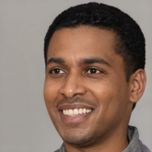 Joyful latino young-adult male with short  black hair and brown eyes