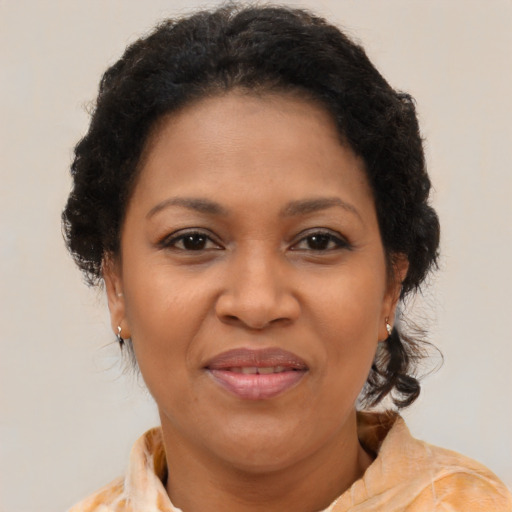 Joyful black adult female with medium  brown hair and brown eyes