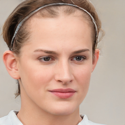 Joyful white young-adult female with short  brown hair and blue eyes