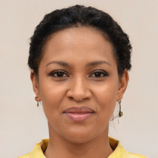 Joyful black young-adult female with short  brown hair and brown eyes