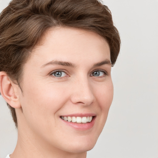 Joyful white young-adult female with short  brown hair and grey eyes