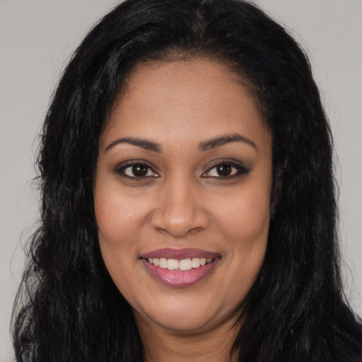 Joyful latino young-adult female with long  black hair and brown eyes