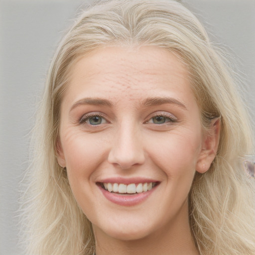 Joyful white young-adult female with long  blond hair and blue eyes