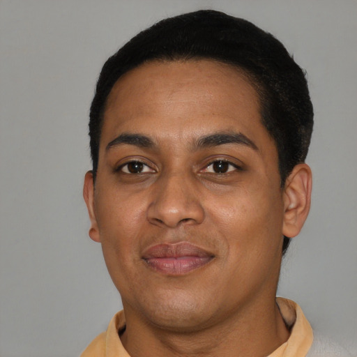 Joyful black young-adult male with short  brown hair and brown eyes