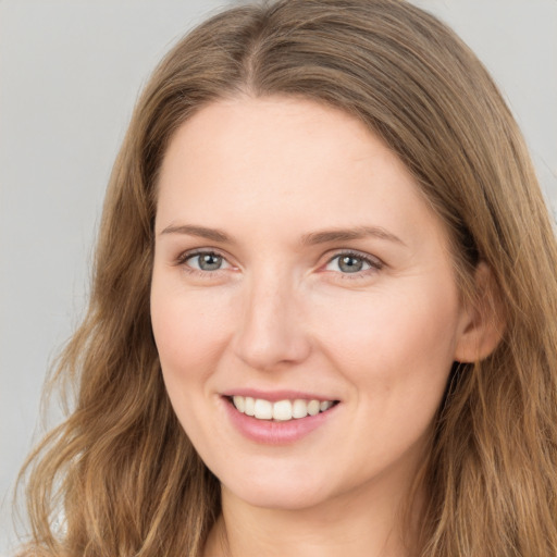 Joyful white young-adult female with long  brown hair and grey eyes