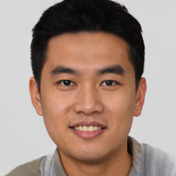 Joyful asian young-adult male with short  black hair and brown eyes