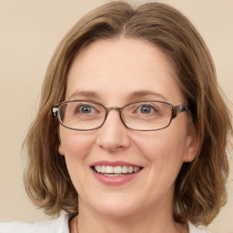 Joyful white adult female with medium  brown hair and green eyes