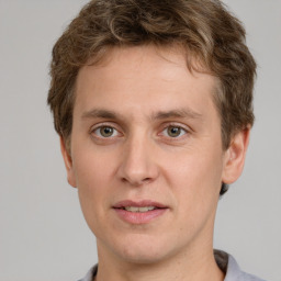 Joyful white young-adult male with short  brown hair and grey eyes