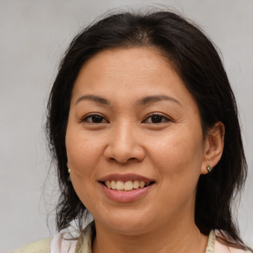 Joyful asian adult female with medium  brown hair and brown eyes