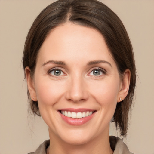 Joyful white young-adult female with medium  brown hair and green eyes