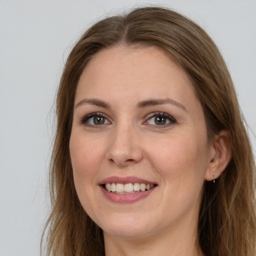 Joyful white young-adult female with long  brown hair and grey eyes