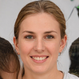 Joyful white young-adult female with medium  brown hair and grey eyes