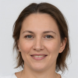 Joyful white adult female with medium  brown hair and brown eyes