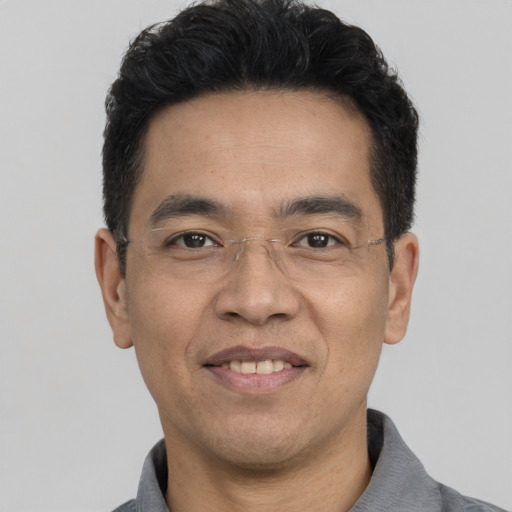 Joyful asian adult male with short  black hair and brown eyes