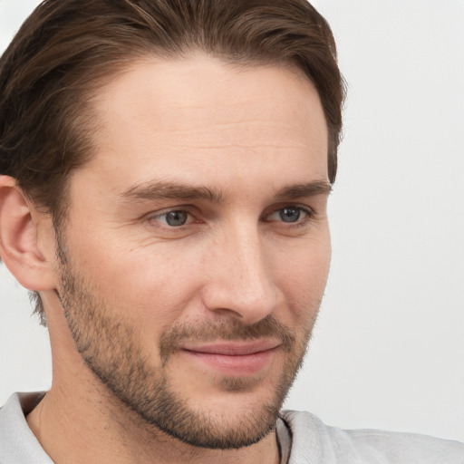 Joyful white young-adult male with short  brown hair and grey eyes