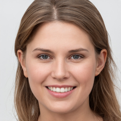 Joyful white young-adult female with long  brown hair and grey eyes