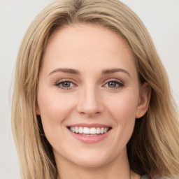 Joyful white young-adult female with long  brown hair and green eyes