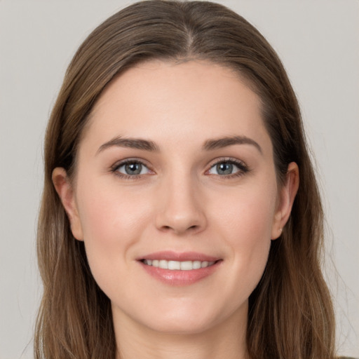 Joyful white young-adult female with long  brown hair and grey eyes