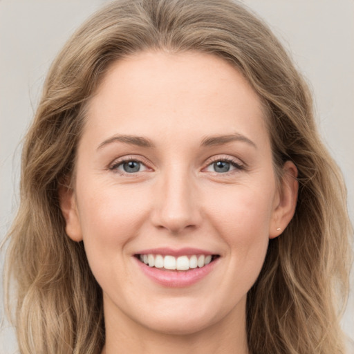 Joyful white young-adult female with long  brown hair and grey eyes