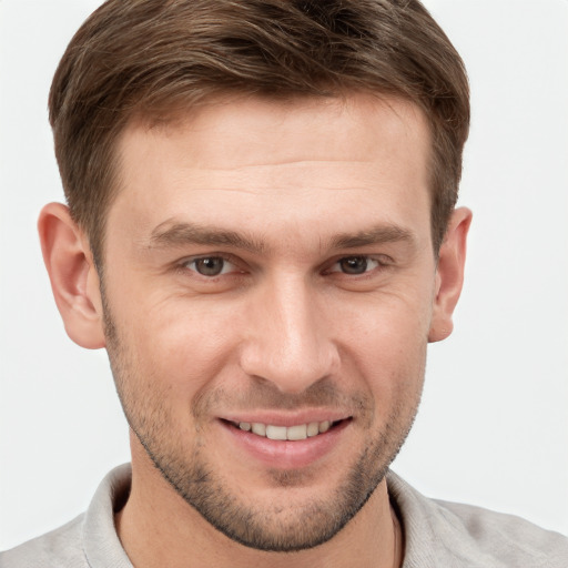 Joyful white young-adult male with short  brown hair and grey eyes